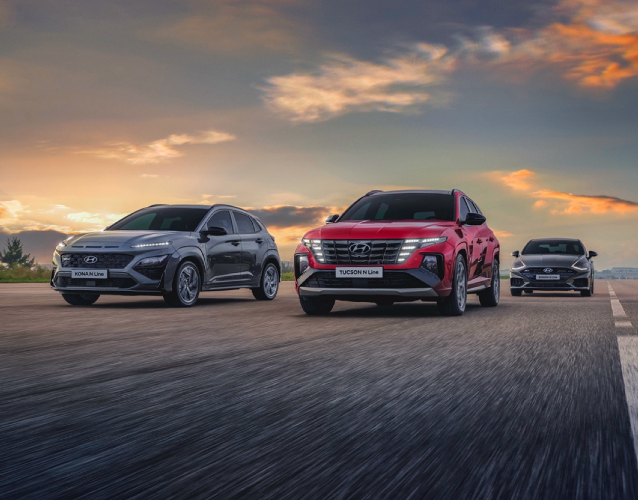 Three Hyundai SUV models driving on a road at sunset