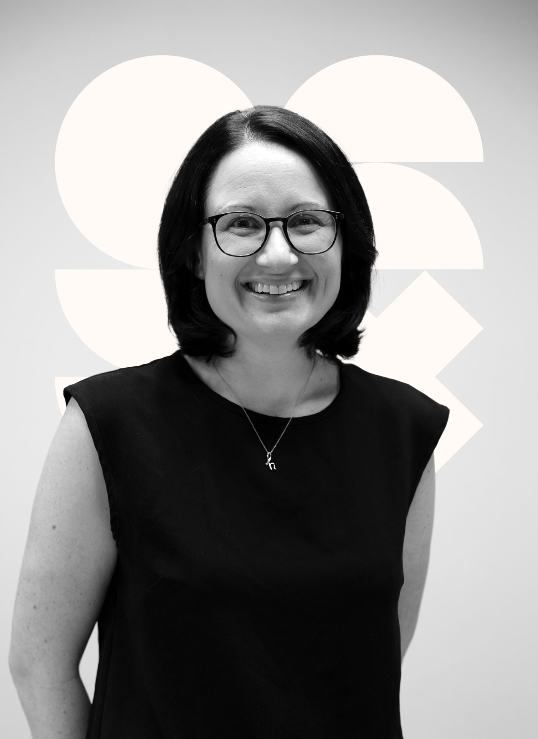 Smiling woman wearing glasses and a black dress