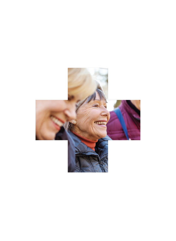 Two elderly women laughing together outdoors